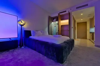 a bedroom with a large bed in a purple room at Stylish Studio with Stunning City Views in Dubai