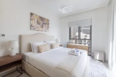 a white bedroom with a large bed and a window at StayShort - Dubai Creek Harbour sleeps 6 in a Great Location in Dubai