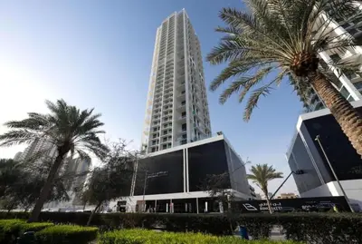 a tall building with palm trees in front of it at Modern 1BD APT In Binghatti Burj Khalifa Skyline in Dubai