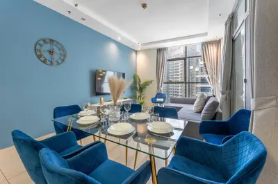 a dining room with blue chairs and a table at Luxury 3BR Dubai Marina Sea & Ain Dubai View in Dubai