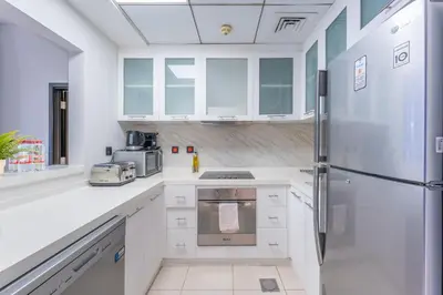a kitchen with white cabinets and a refrigerator at Luxury 3BR Dubai Marina Sea & Ain Dubai View in Dubai