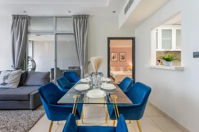 a dining room with a table and blue chairs at Luxury 3BR Dubai Marina Sea & Ain Dubai View in Dubai