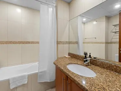 a bathroom with a sink and a shower and a tub at 1BR in JLT, Steps from Metro, Marina & Mall in Dubai