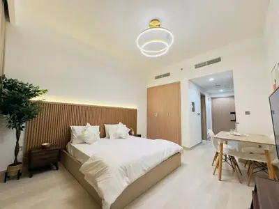 a bedroom with a bed and a table and a desk at Mahenti – Elegant Studio Apartment | Azizi Riviera in Dubai