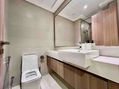 a bathroom with a sink and a toilet and a mirror at Mahenti - Contemporary Studio Living in Meydan in Dubai