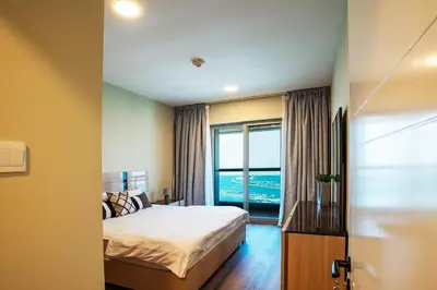a bedroom with a bed and a large window at Stylish 2BR Balcony Palm Jumeirah Views in Dubai