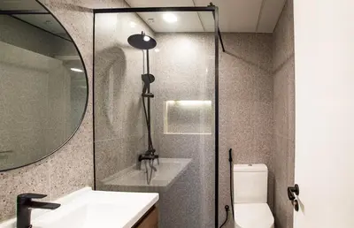a bathroom with a shower and a sink and a mirror at Stylish 2BR Balcony Palm Jumeirah Views in Dubai