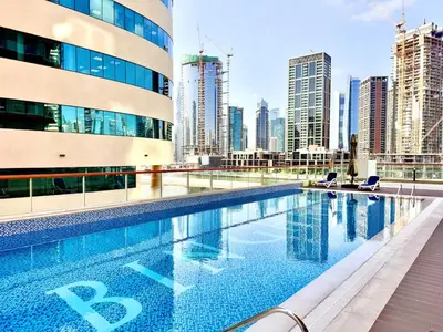 a swimming pool in a city with tall buildings at Mahenti - 1BR - Stunning Lake & Burj Khalifa Views in Dubai