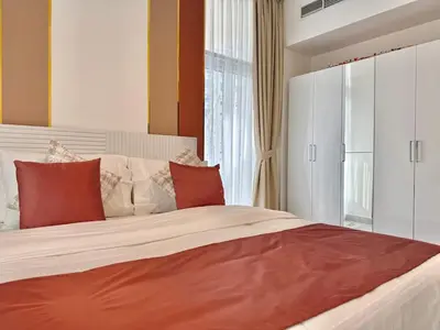 a bedroom with a large bed with red and white pillows at Mahenti - 1BR - Stunning Lake & Burj Khalifa Views in Dubai