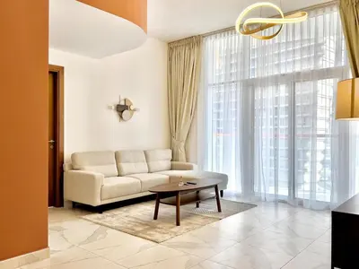 a living room with a couch and a table at Mahenti - 1BR - Stunning Lake & Burj Khalifa Views in Dubai