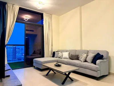a living room with a couch and a table at Mahenti - Sunlit Spacious Apartment in JVC in Dubai