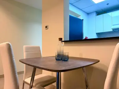 a table with two glasses and a bottle on it at Mahenti - Sunlit Spacious Apartment in JVC in Dubai
