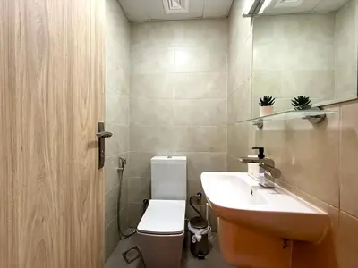a small bathroom with a sink and a toilet at Mahenti - Sunlit Spacious Apartment in JVC in Dubai