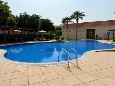 a large blue swimming pool in a courtyard at Mahenti - Bright & Cozy Studio Metro Accessible in Dubai