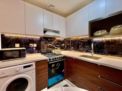 a kitchen with a stove and a sink and a dishwasher at Mahenti - Jewelz · With balcony easy to pool & gym in Dubai