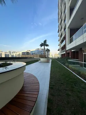 a walkway next to a building with a palm tree at Mahenti - Jewelz · With balcony easy to pool & gym in Dubai
