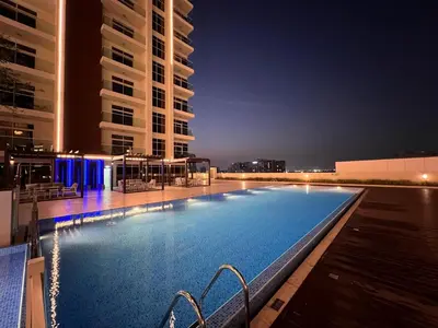 a large swimming pool at night with tall buildings at Mahenti - Jewelz · With balcony easy to pool & gym in Dubai