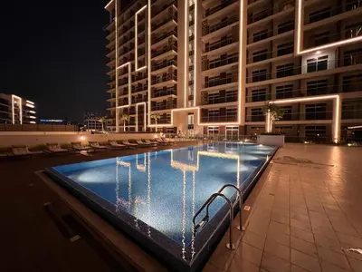 a swimming pool in front of a building at night at Mahenti - Jewelz · With balcony easy to pool & gym in Dubai