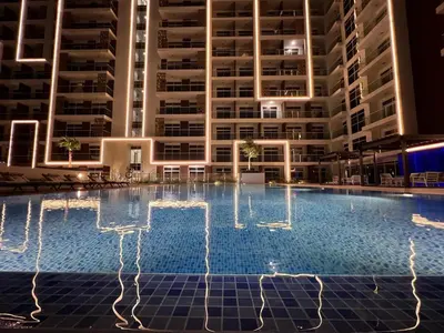 an empty pool in front of a building at night at Mahenti - Jewelz · With balcony easy to pool & gym in Dubai