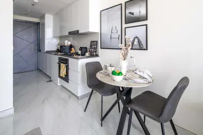a kitchen with a table and chairs in a room at Frank Porter - Samana Golf Avenue in Dubai
