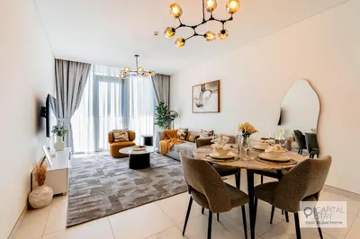 a dining room and living room with a table and chairs at Capital Stay - 1 Bed Apt in MBR City in Dubai