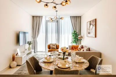 a living room with a table and a couch at Capital Stay - 1 Bed Apt in MBR City in Dubai