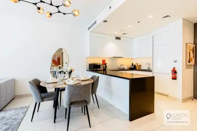 a kitchen and dining room with a table and chairs at Capital Stay - 1 Bed Apt in MBR City in Dubai