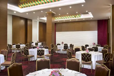a banquet room with tables and chairs and a projection screen at Atana Hotel in Dubai