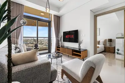 a living room with a couch and a tv at Elegant 1BR Flat in Business Bay with Pool & Gym in Dubai