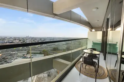 a balcony with two chairs and a view of a city at Elegant 1BR Flat in Business Bay with Pool & Gym in Dubai