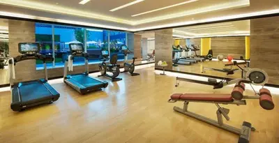 a gym with several cardio machines in a room at DAMAC Maison Cour Jardin - Pool & Gym - Free Parking in Dubai