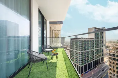 a balcony with chairs and a table on a building at Deluxe Binghatti JVC Suites by Hostiva - City View in Dubai