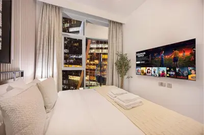 a bedroom with a white bed and a large window at Mahogany 20 - 1BR 4PAX - Infinity Pool & Spacious in Dubai