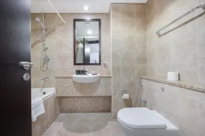 a bathroom with a toilet and a sink and a tub at StayShort - Extravagant Studio in DIFC with Skyline Views in Dubai