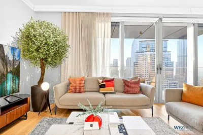 a living room with a couch and a large window at Iconic 4BR with Burj & Fountain Views Boulevard Point in Dubai