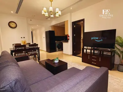 a living room with a purple couch and a tv at Spacious 1 Bed with Burj Khalifa View accommodates 3 or 4 in Dubai