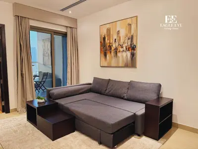a living room with a couch and a painting at Spacious 1 Bed with Burj Khalifa View accommodates 3 or 4 in Dubai