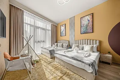 two beds in a room with yellow walls at Downtown Luxury 2 Bedroom Apartment with Iconic Burj Khalifa Views, Rooftop Pool, Movie Room, Squash Court, and Kids Club in Dubai