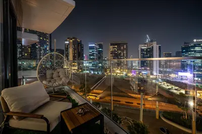 a balcony with a view of a city at night at Downtown Luxury 2 Bedroom Apartment with Iconic Burj Khalifa Views, Rooftop Pool, Movie Room, Squash Court, and Kids Club in Dubai