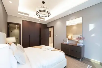 a bedroom with a white bed and a large mirror at Trophy Soft tones sharp style Masterpiece 705 in Dubai