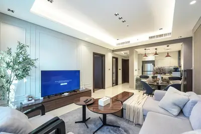 a living room with a couch and a tv at Trophy Soft tones sharp style Masterpiece 705 in Dubai