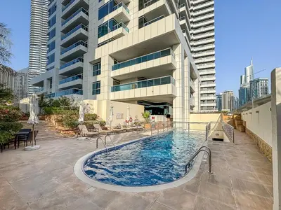 a swimming pool in front of a tall building at Modern 2 Bed with Waterfront Views, Gym & Pool in Dubai