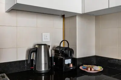 a coffee pot on a counter in a kitchen at Stylish 1-Bedroom with Balcony & Amenities in Marina in Dubai