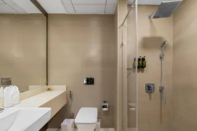 a bathroom with a shower and a toilet and a sink at Stylish 1-Bedroom with Balcony & Amenities in Marina in Dubai