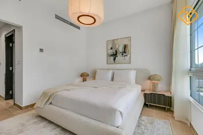 a white bedroom with a large bed and a window at Brand new Large Villa JVT Private Garden in Dubai