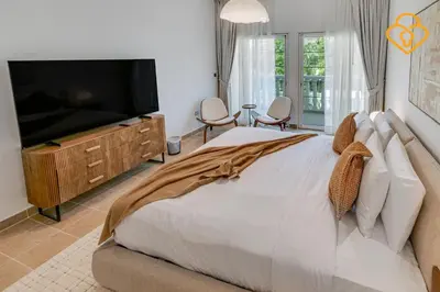 a bedroom with a large bed and a flat screen tv at Brand new Large Villa JVT Private Garden in Dubai