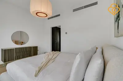 a white bedroom with a couch and a mirror at Brand new Large Villa JVT Private Garden in Dubai