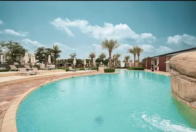 a swimming pool with blue water in a resort at 3 BR W Maid Walk to Pool, Arabian Ranches III Ruba in Dubai