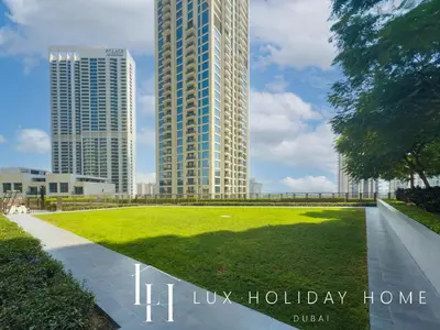a park with a tall building in the background at LUX The Creekside Skyline View Suite in Dubai