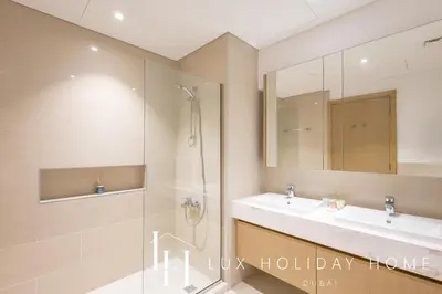 a bathroom with a shower and a sink at LUX The Creekside Skyline View Suite in Dubai